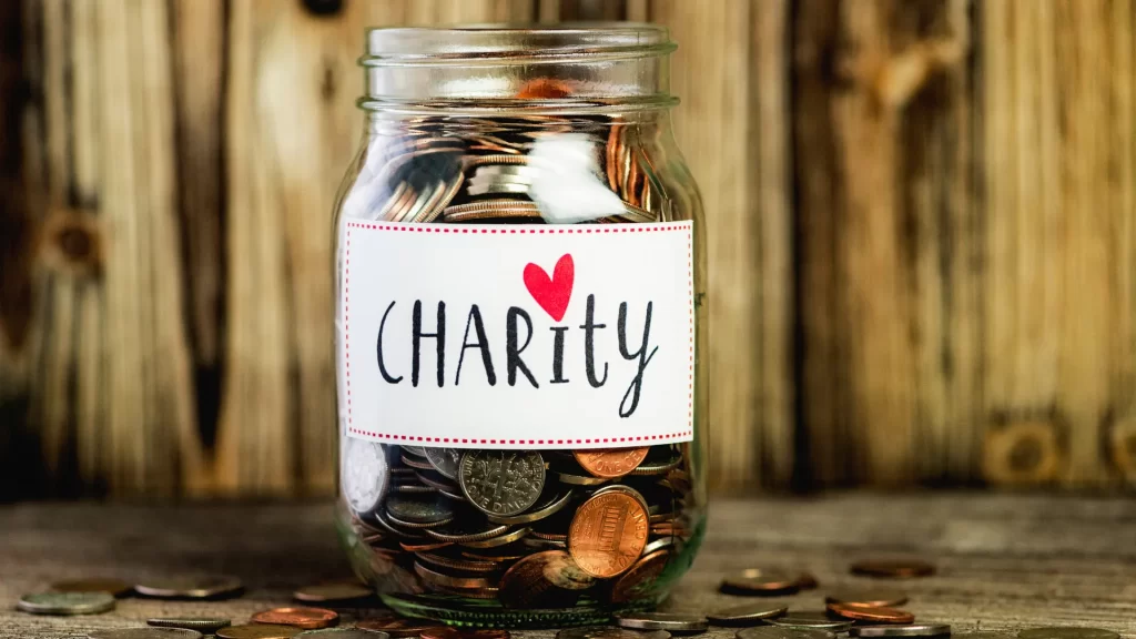 What does charity and sincerity mean? A jar full of coins with a "Charity" label on it, showing the meaning of generosity and kindness.