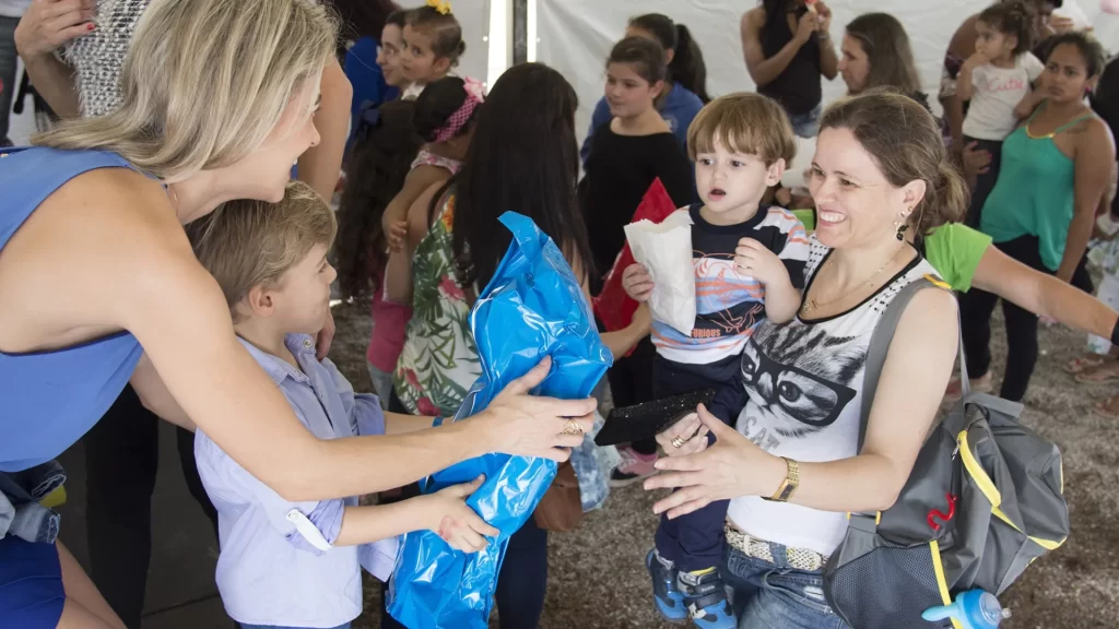 A woman handing out supplies to families in need, embodying the true spirit of charity and compassion.
