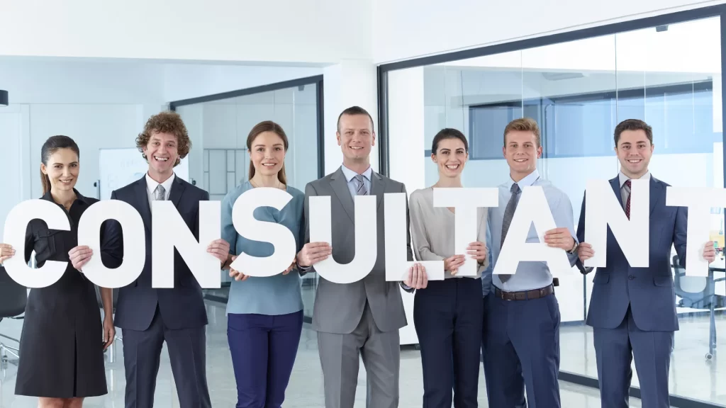 A group of professionals holding large letters spelling 'CONSULTANT,' symbolizing the field of educational consulting.