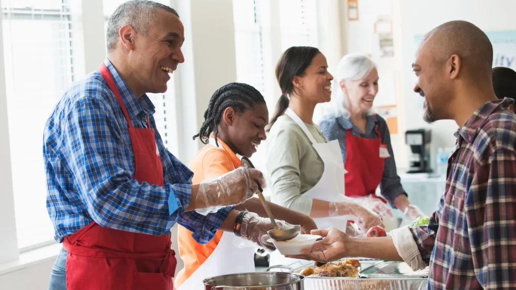 Volunteers helping in a community kitchen, highlighting the activities that count as community service, such as providing food to those in need.